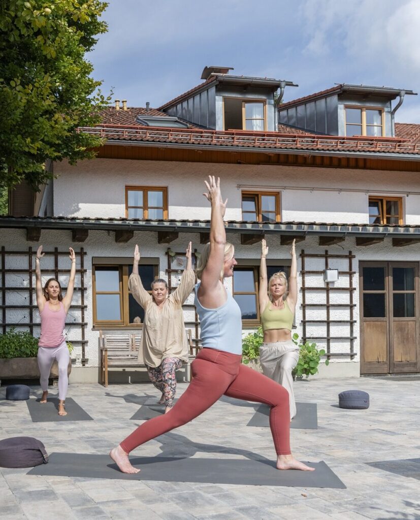 Yogagruppe macht auf der Terrasse im Mountain Retreat Center gemeinsam Yogaübungen